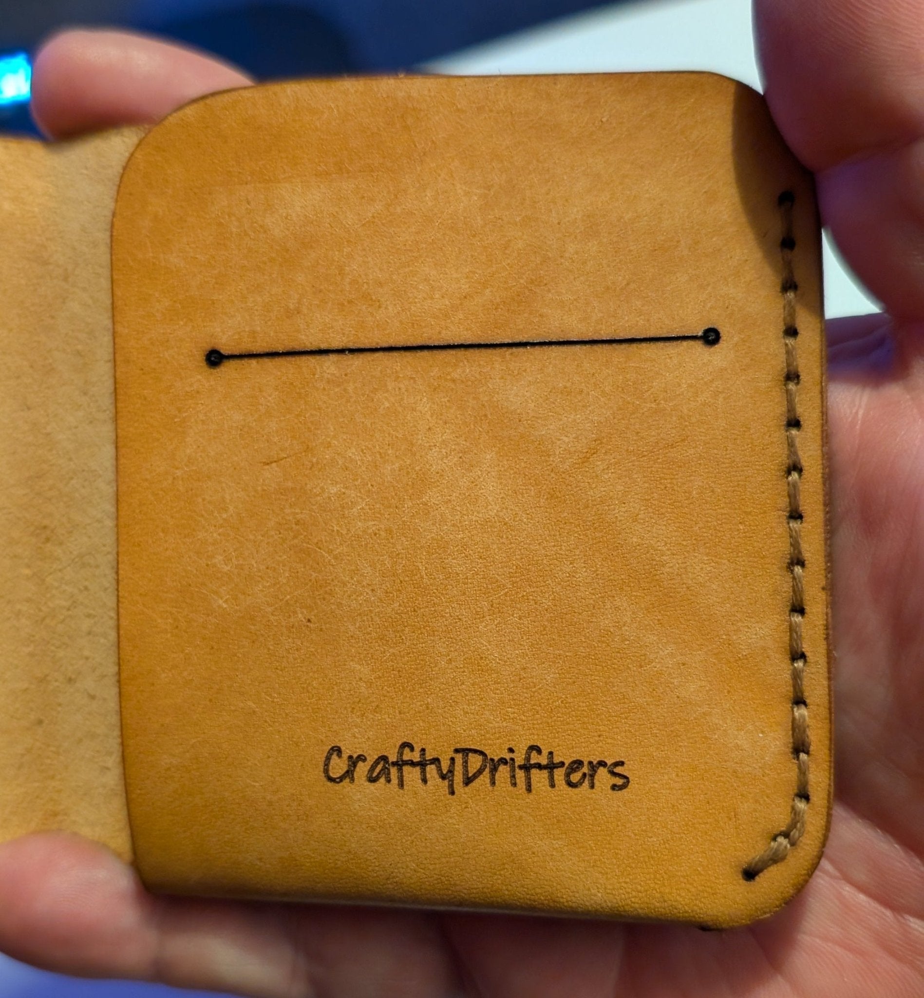 Alt Tag: Compact Bi-Fold Wallet single piece of Maya leather in cognac close-up interior stitching and logo, slim handmade leather wallet