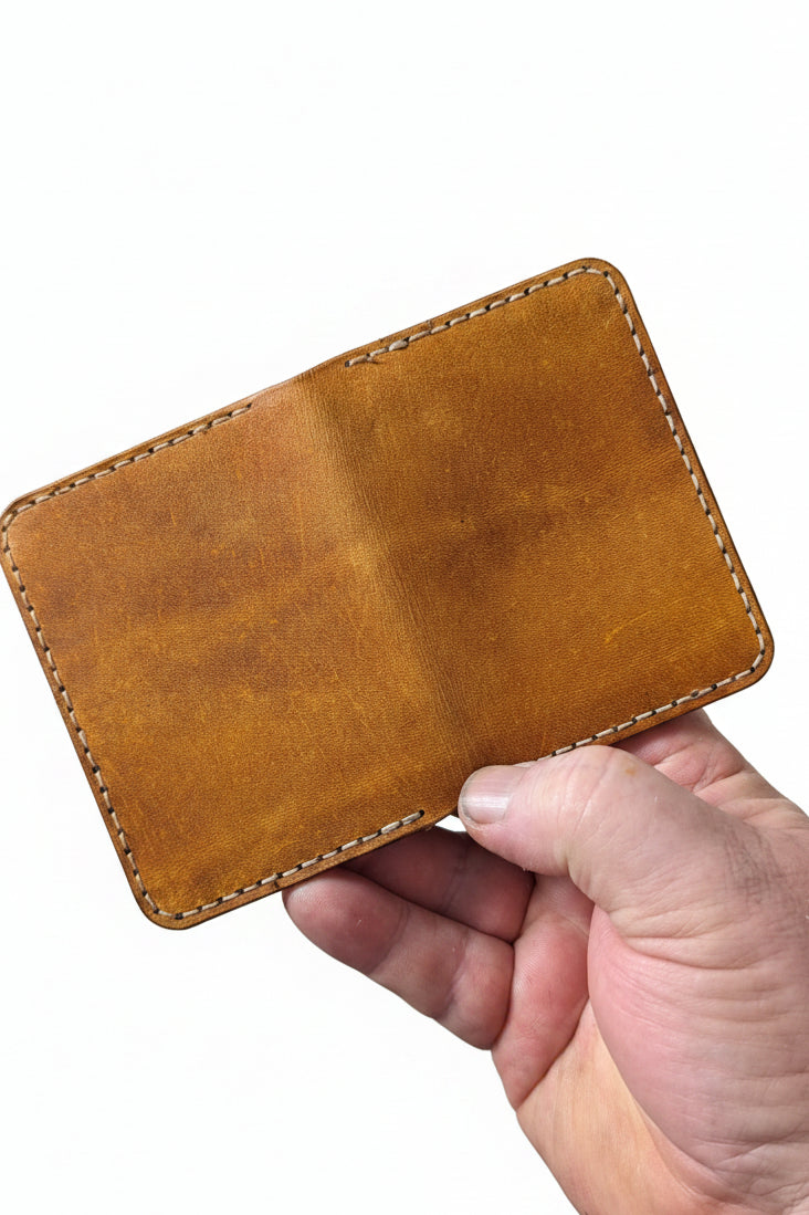 Low profile handmade bi-fold leather wallet crafted from full-grain leather with slim, stylish design and multiple compartments