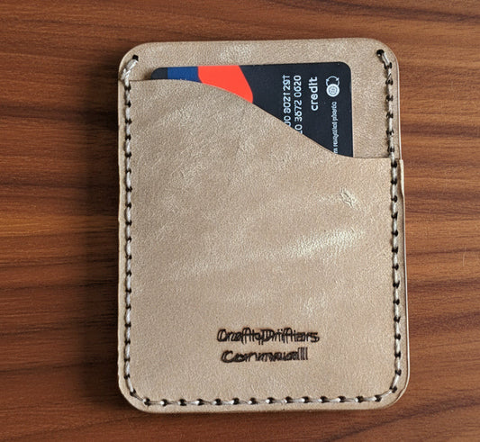 Compact Card Sleeve with compass engraving holding a credit card, showcasing minimalist design and craftsmanship.