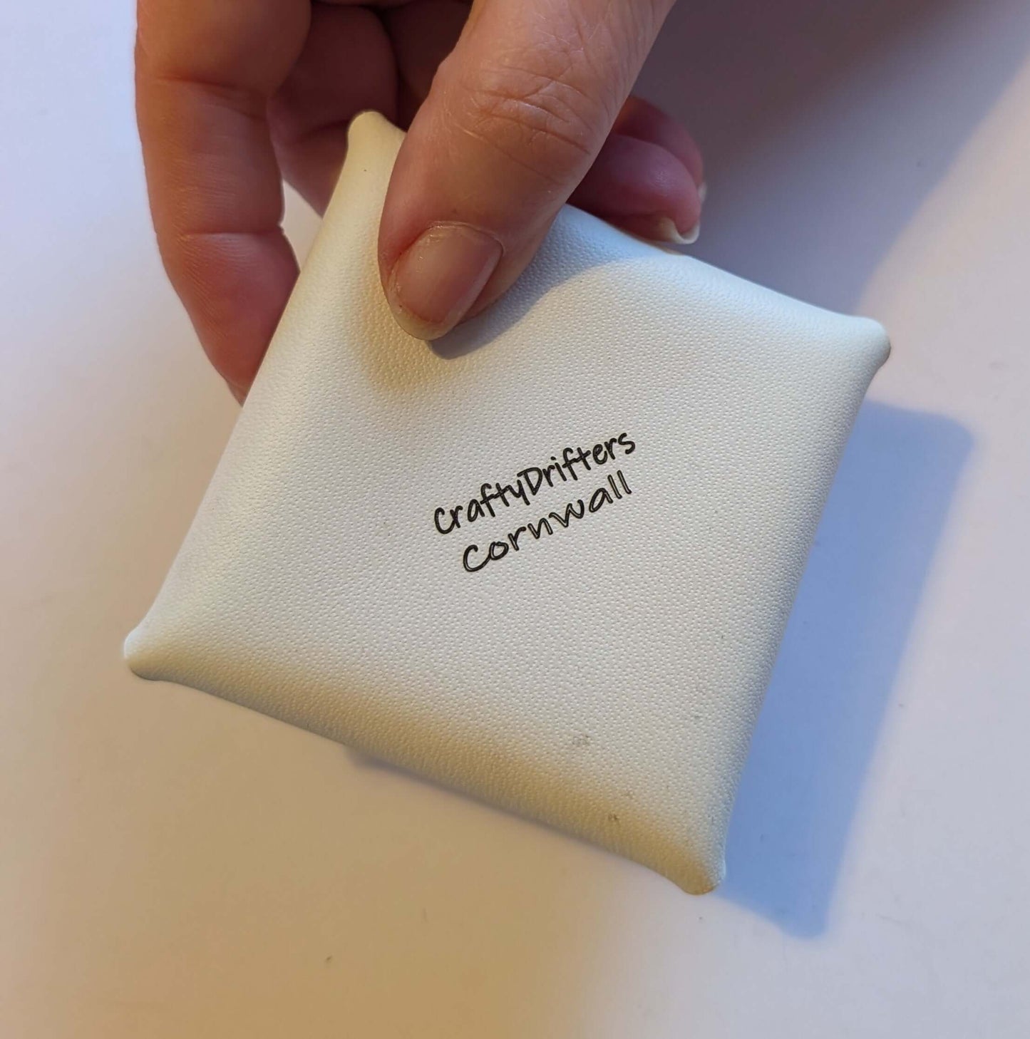 Stitch free leather coin purse held in hand, featuring a smooth design and logo from CraftyDrifters Cornwall.