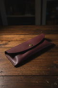 Soft glasses case in metallic red chrome-tanned leather with hand-stitched detailing and press stud closure