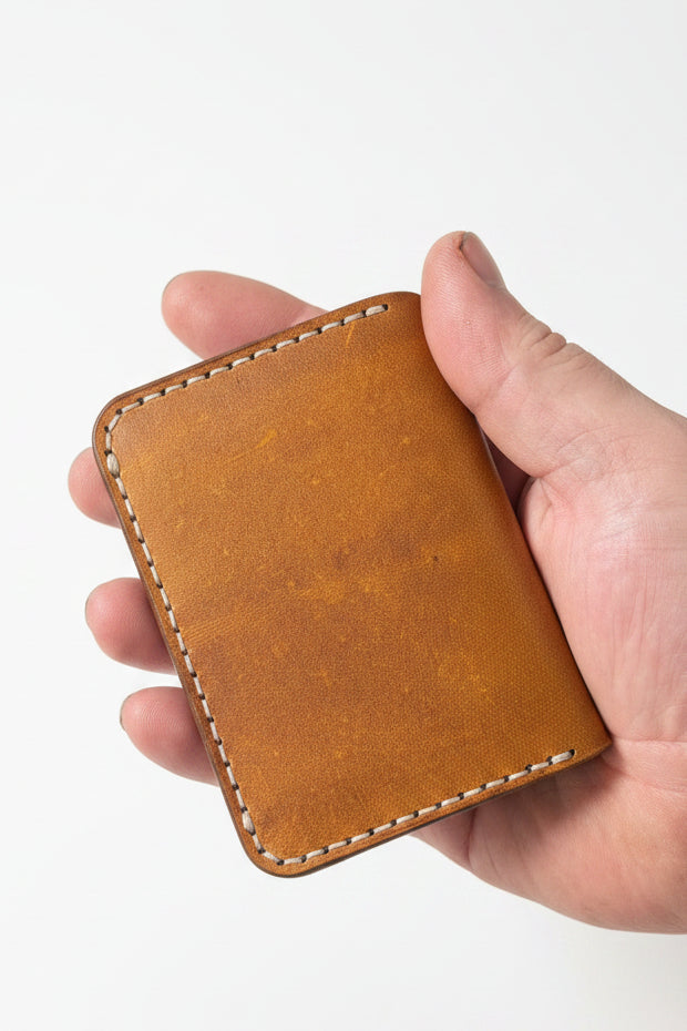 Low profile handmade bi-fold leather wallet crafted from full-grain leather with slim design and multiple card slots